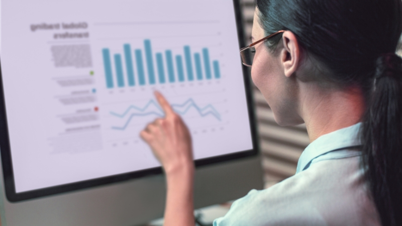 Professional reviewing charts on a computer screen to improve business strategy with strong analytical skills