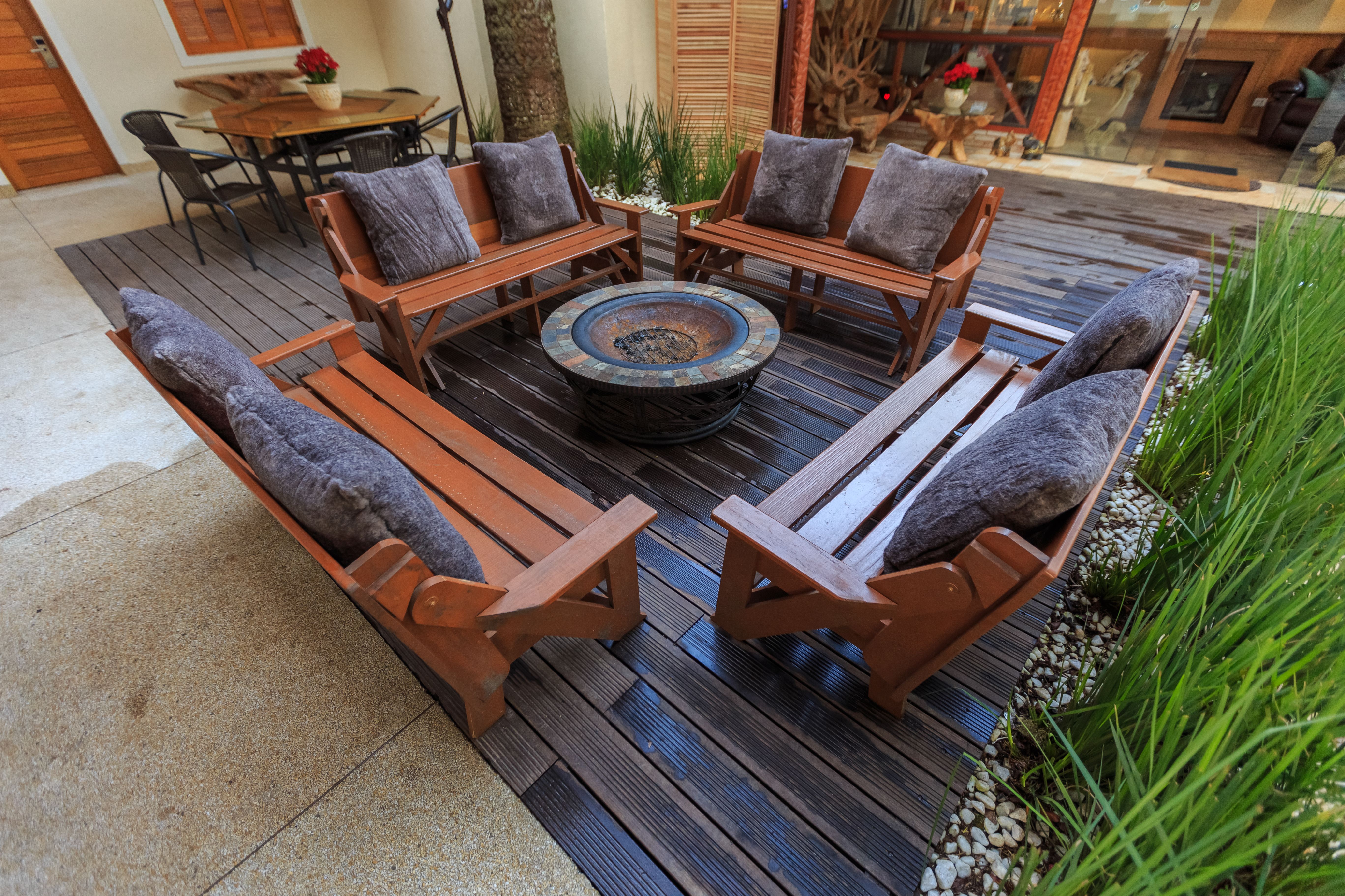 Outdoor lounge with wooden benches and a central fire pit for evening gatherings