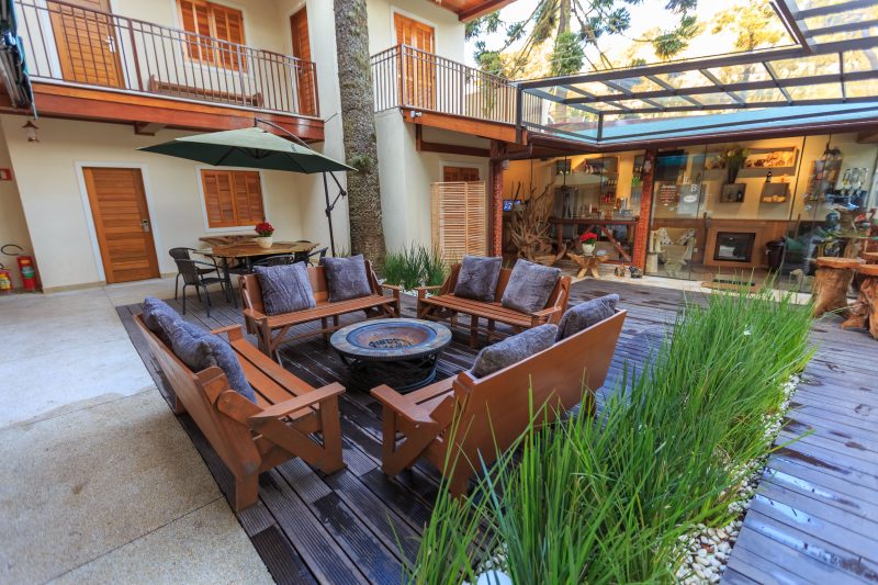 Modern outdoor patio with wooden seating and lush plants in a residential courtyard